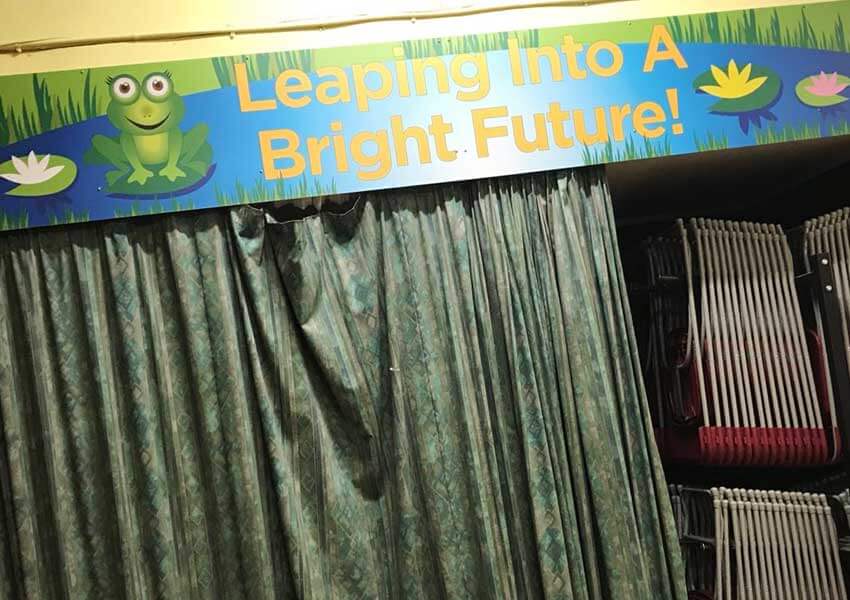The stage area in the main hall of the school was transformed with a display featuring the school motto.