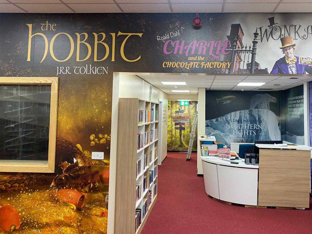 School library wall art depicting scenes from famous novels