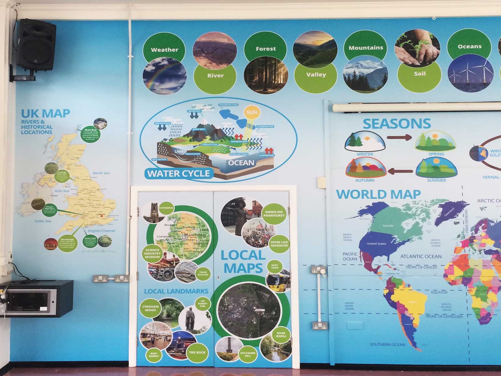 High-quality school wall graphics in a school hall showing detailed UK and European maps for primary education.
