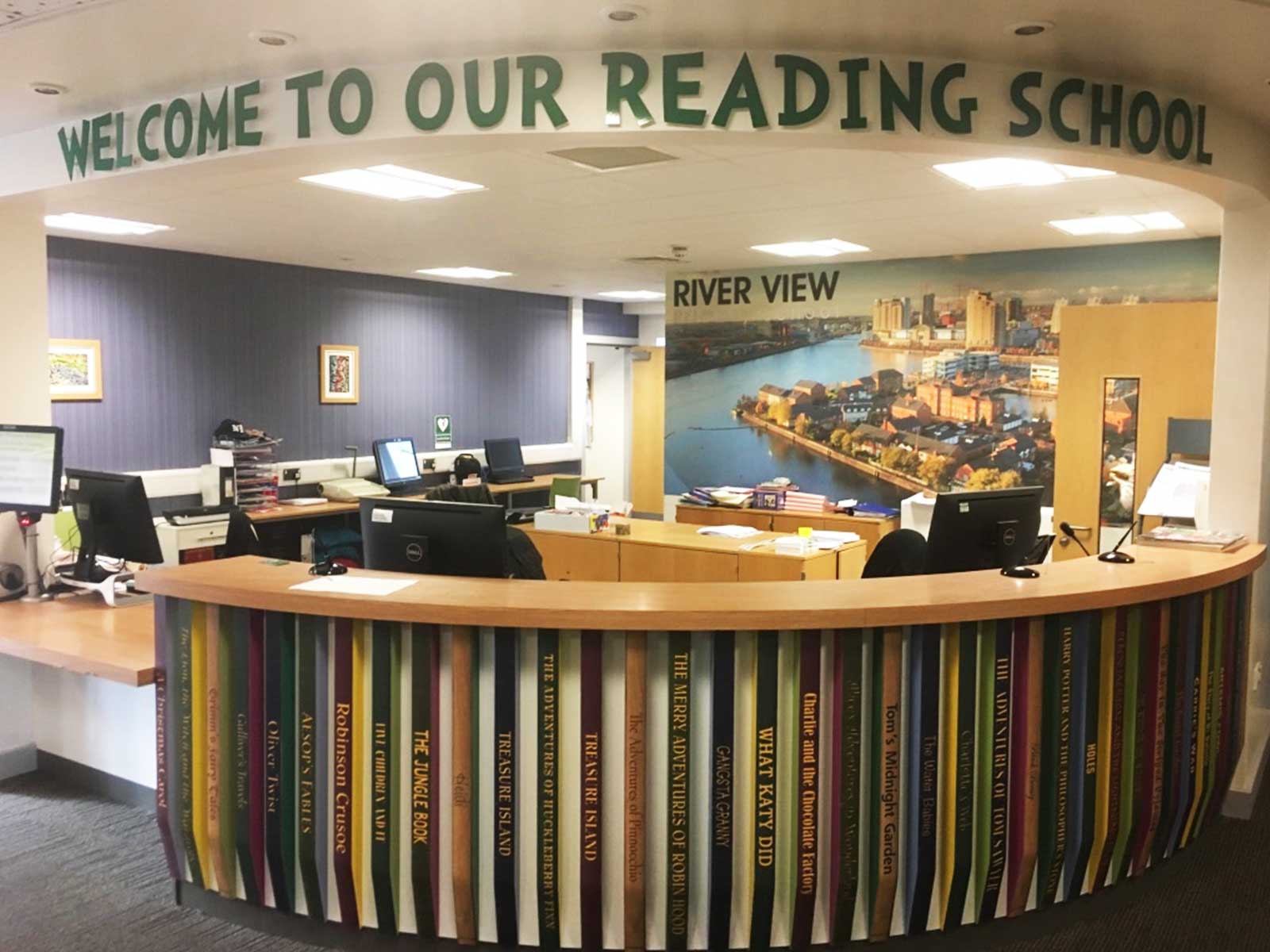 A school reception desk transformed into famous book spines using durable wall art.